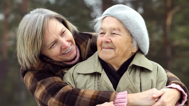 adult daughter hugging elderly mom